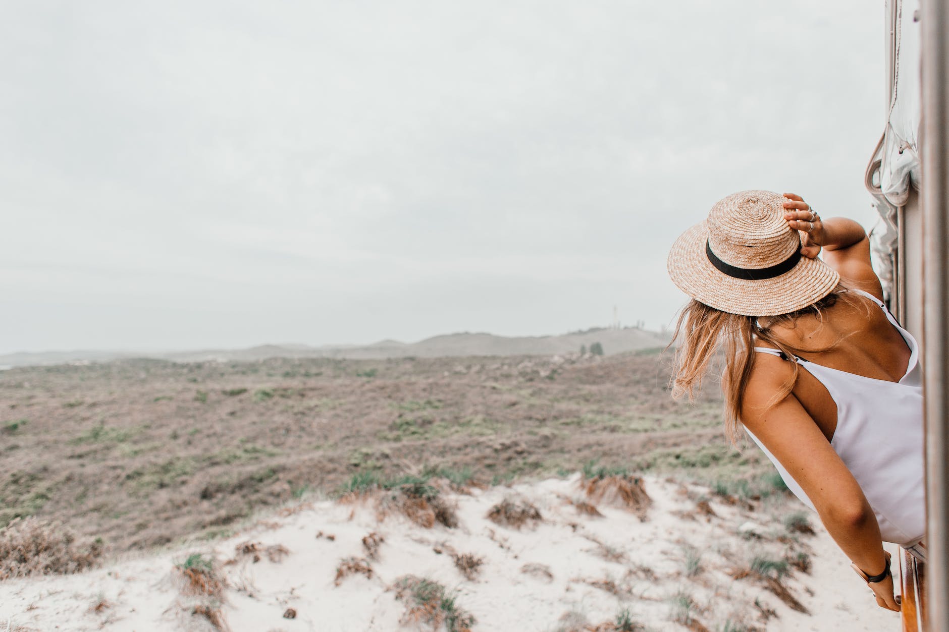 woman in straw hat looking at desert lands