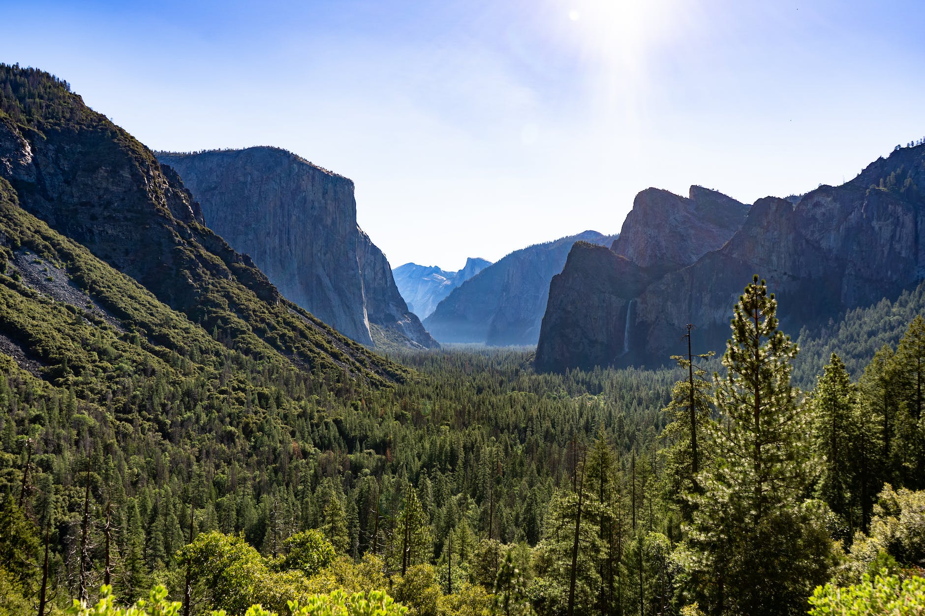 green trees near mountain under white clouds
